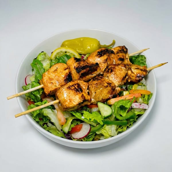 Grilled chicken skewers with lemon and pepperoncini, served over a fresh garden salad.