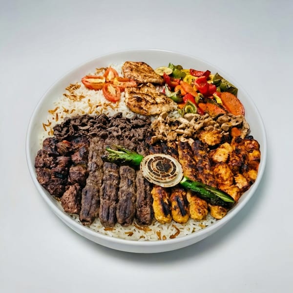 A large platter of rice topped with grilled chicken, beef, vegetables, and tomatoes.