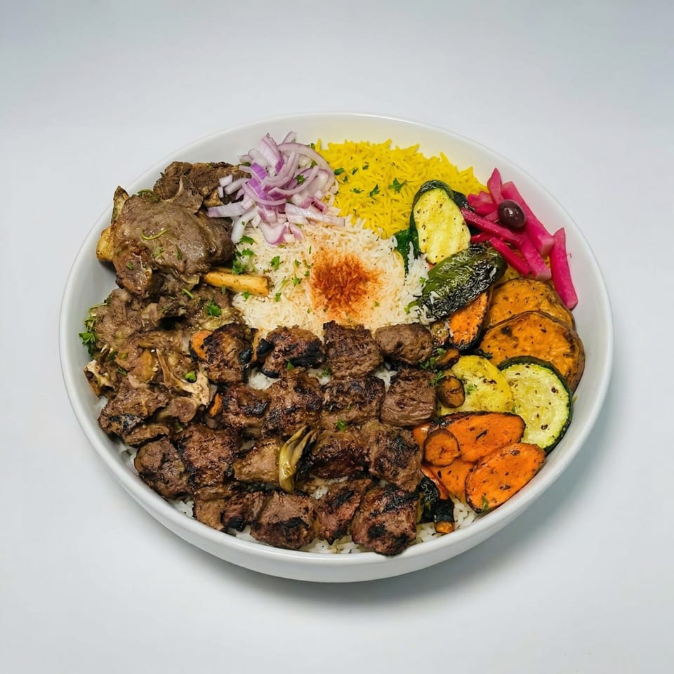 A large white bowl filled with grilled meats, yellow and white rice, and roasted vegetables.